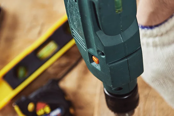 Hand bohrt mit Bohrmaschine in Holz